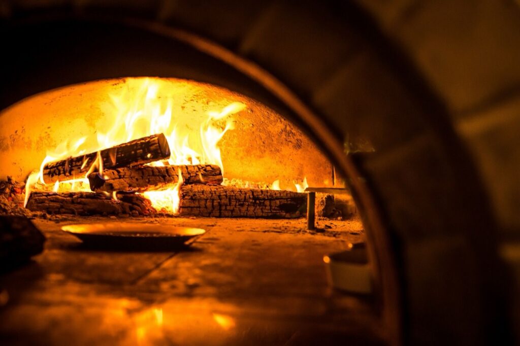 Split logs burning inside a brick wood-fired oven