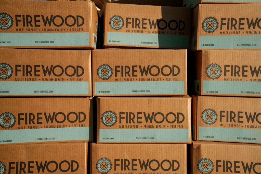 Stacked cardboard boxes of Standard Firewood printed with the company logo